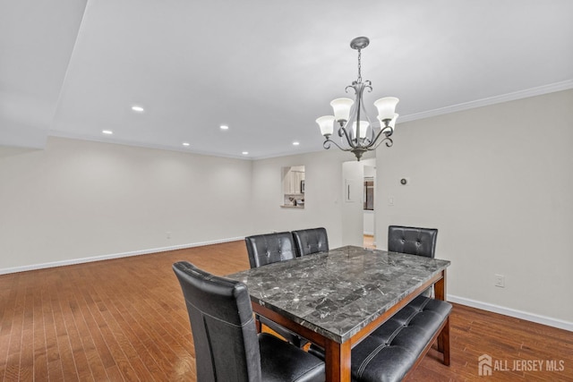 dining room with ornamental molding, a chandelier, and hardwood / wood-style floors