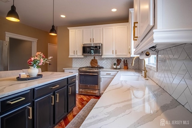 29 Mitchell Dr, Monroe, NJ 08831 - kitchen featuring appliances with stainless steel finishes, white cabinets, decorative light fixtures, wood finished floors, and backsplash