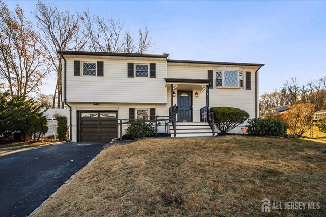 raised ranch featuring a garage and a front yard