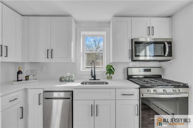 8 1st St, Sayreville, NJ 08872 - kitchen featuring appliances with stainless steel finishes, a sink, white cabinets, and light countertops