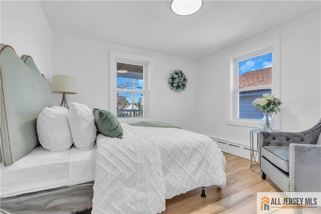 8 1st St, Sayreville, NJ 08872 - bedroom with a baseboard heating unit and light wood-style flooring