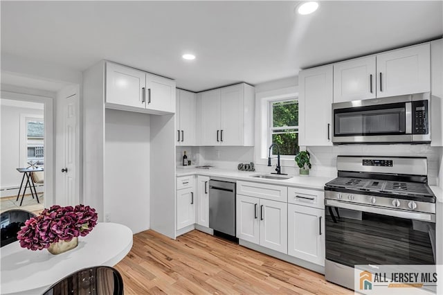 8 1st St, Sayreville, NJ 08872 - kitchen with appliances with stainless steel finishes, a sink, light countertops, white cabinetry, and recessed lighting