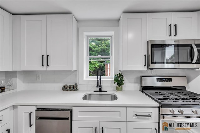 8 1st St, Sayreville, NJ 08872 - kitchen with appliances with stainless steel finishes, a sink, decorative backsplash, and white cabinetry