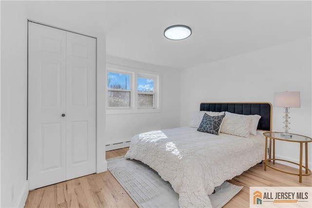 8 1st St, Sayreville, NJ 08872 - bedroom featuring baseboard heating, wood finished floors, and a closet