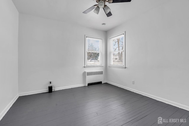 spare room featuring ceiling fan, dark wood-type flooring, and radiator heating unit