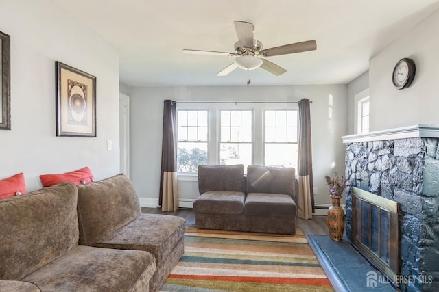living area featuring a baseboard heating unit, ceiling fan, wood finished floors, and baseboards