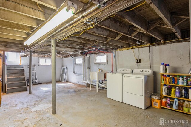 basement with a sink, washing machine and clothes dryer, and stairway