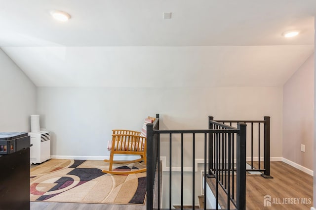 interior space with lofted ceiling, wood finished floors, and baseboards