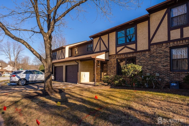 tudor home featuring a garage and a front yard