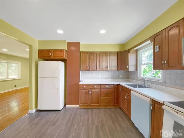15 Race Track Rd, East Brunswick, NJ 08816 - kitchen with white appliances, light wood-style floors, light countertops, backsplash, and brown cabinets