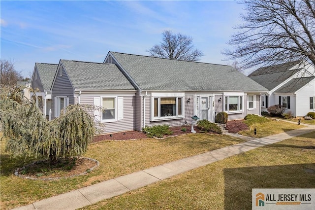 cape cod house featuring a front yard and a shingled roof