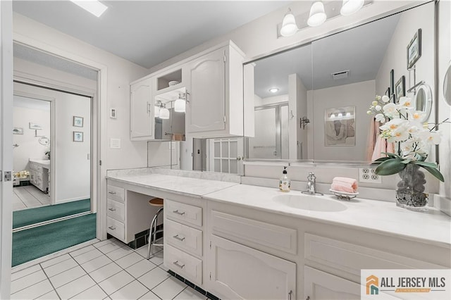 bathroom featuring tile patterned floors, visible vents, a stall shower, and vanity