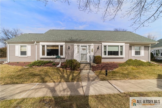 ranch-style home featuring a shingled roof and a front lawn