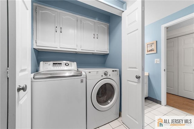 laundry room with washer and dryer, baseboards, cabinet space, and light tile patterned floors