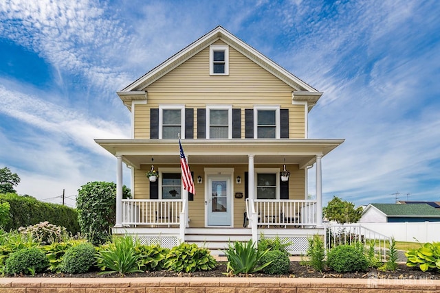 view of front of property featuring a porch and fence