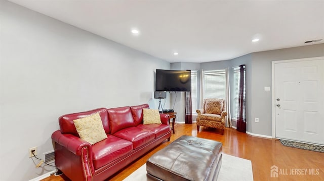 living area featuring baseboards, recessed lighting, visible vents, and wood finished floors