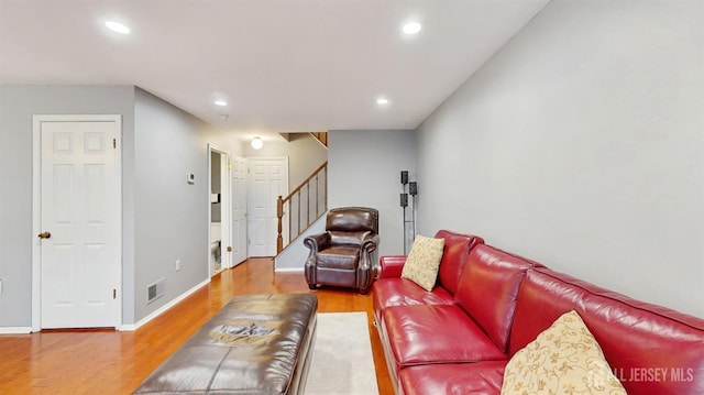 living area with stairs, recessed lighting, visible vents, and wood finished floors