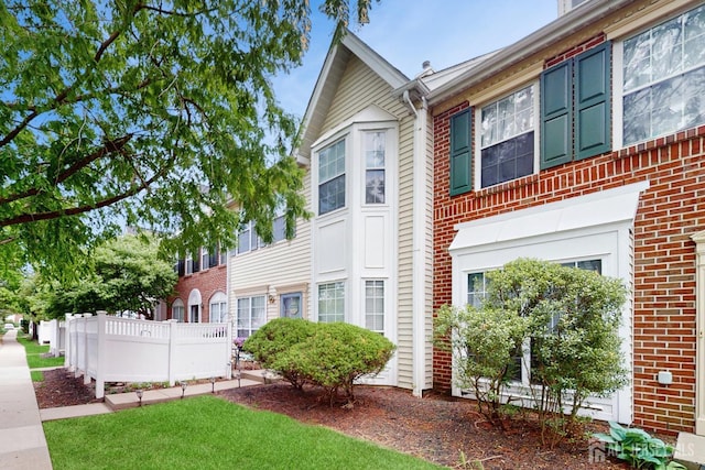 exterior space with brick siding and fence