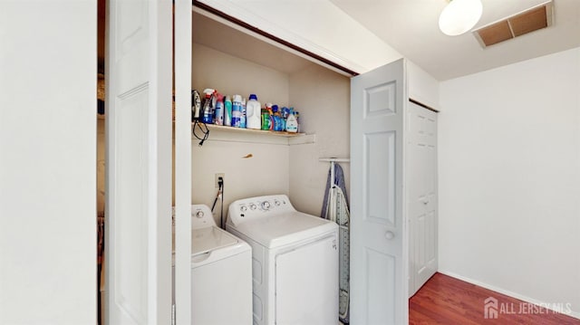 laundry area with separate washer and dryer, laundry area, visible vents, and wood finished floors