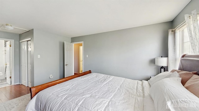 bedroom with wood finished floors and a closet