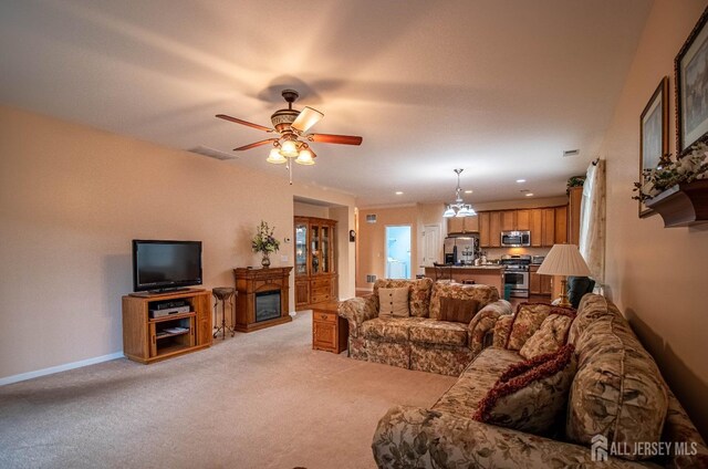 living room with light carpet, ceiling fan, and a glass covered fireplace