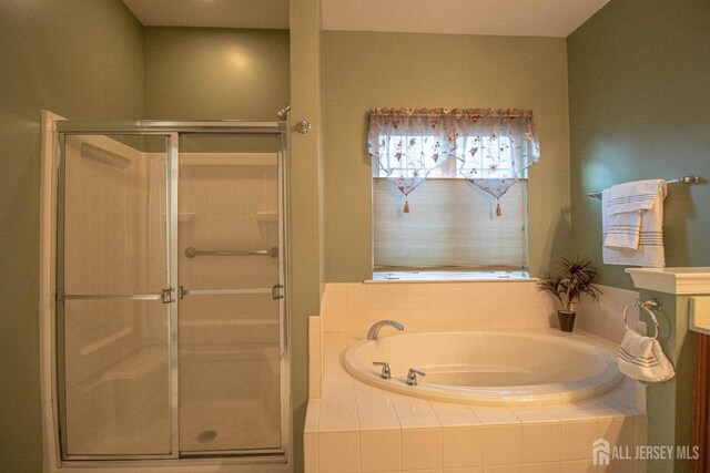 full bathroom featuring a garden tub and a shower stall