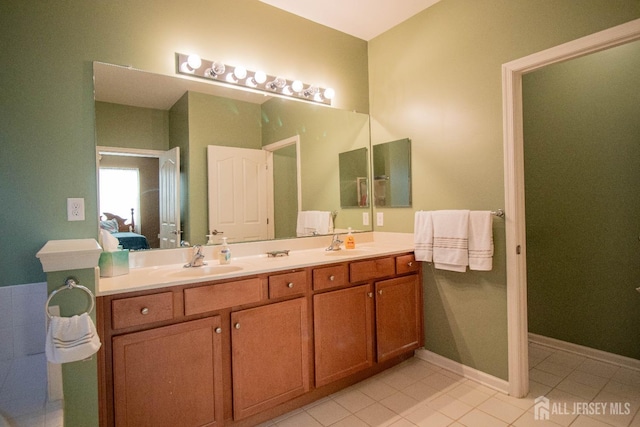 bathroom featuring ensuite bath, double vanity, and tile patterned flooring