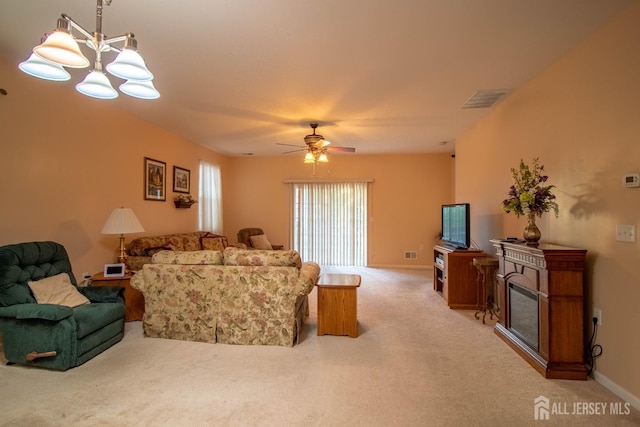living area featuring light colored carpet, a chandelier, a ceiling fan, and baseboards