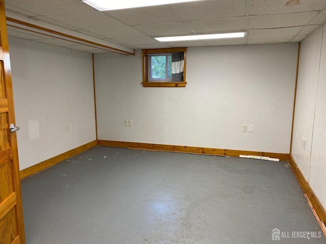 below grade area featuring baseboards and a drop ceiling