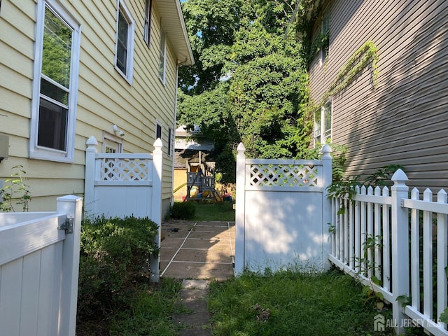 view of property exterior with fence and a playground