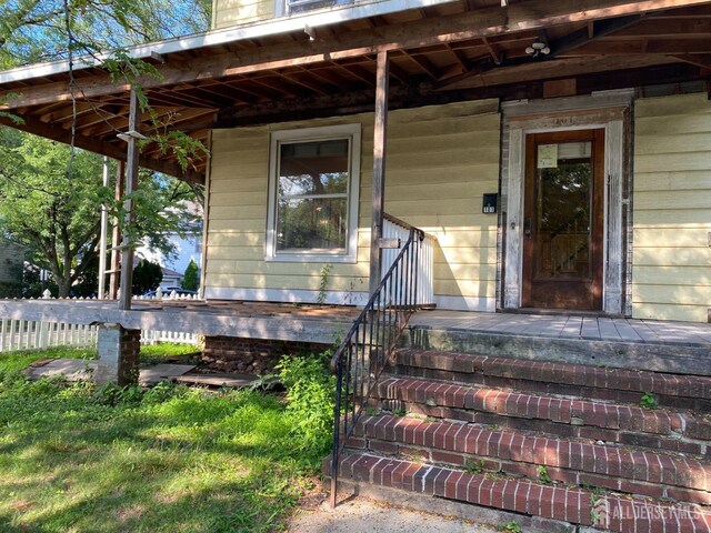 view of exterior entry with a porch