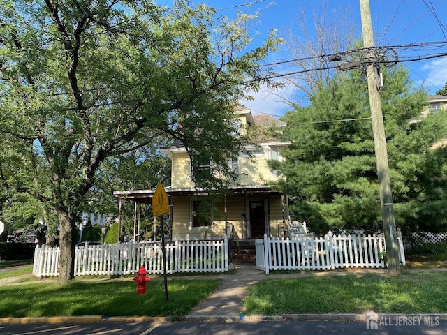 view of front of home with a fenced front yard and covered porch