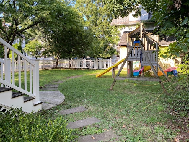 view of yard featuring fence and a playground