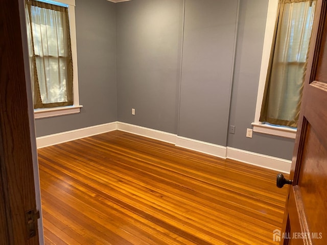 spare room with wood finished floors and baseboards