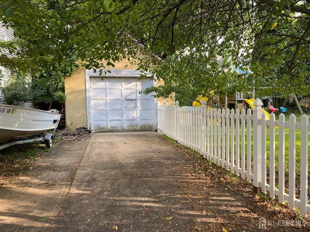 garage with driveway and fence