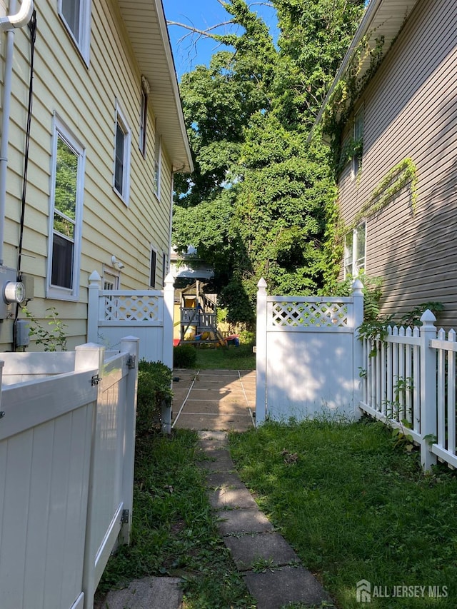 view of home's exterior featuring a playground and fence