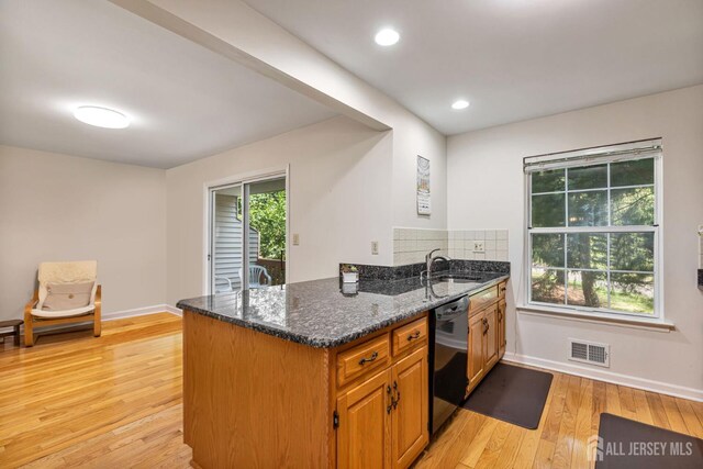 183 Driscoll Ct, Franklin Twsp, NJ 08873 - kitchen featuring dishwasher, light wood finished floors, dark stone counters, a peninsula, and tasteful backsplash