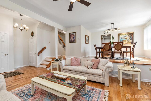 183 Driscoll Ct, Franklin Twsp, NJ 08873 - living area with stairs, a chandelier, wood finished floors, and ceiling fan