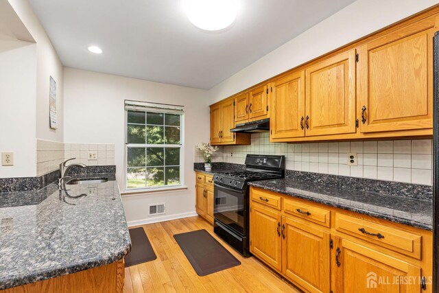 183 Driscoll Ct, Franklin Twsp, NJ 08873 - kitchen featuring black gas stove, under cabinet range hood, dark stone countertops, light wood-style flooring, and recessed lighting