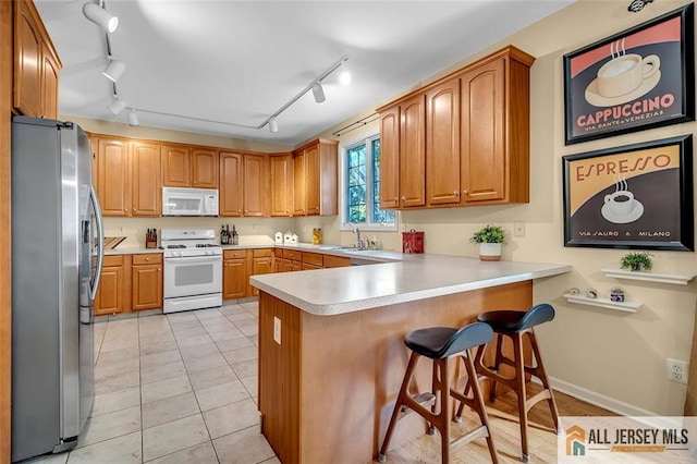 2 Danser Dr, Cranbury, NJ 08512 - kitchen with white appliances, a peninsula, track lighting, and light countertops