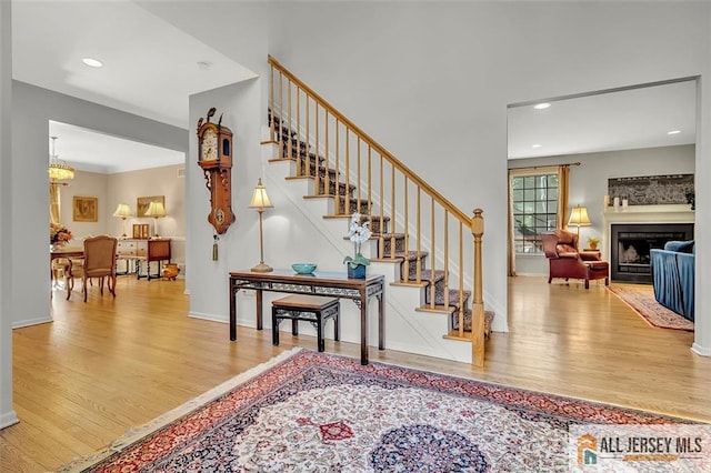 2 Danser Dr, Cranbury, NJ 08512 - stairway featuring wood finished floors, recessed lighting, a fireplace, and a chandelier