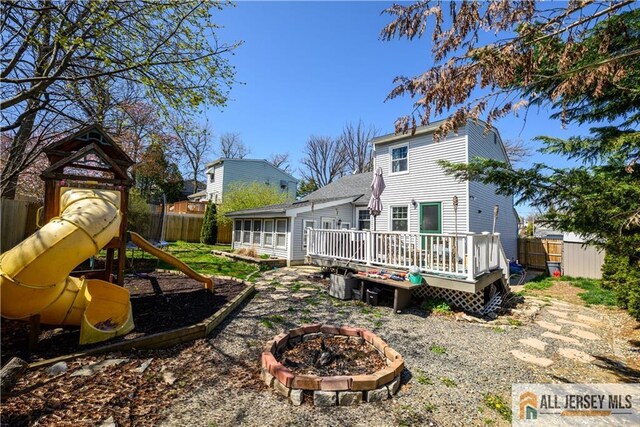 7 Hollywood St, South River, NJ 08882 - rear view of property featuring a playground, a fire pit, and a deck