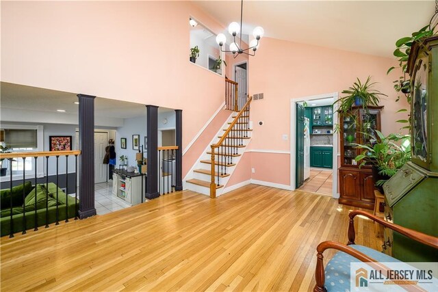 7 Hollywood St, South River, NJ 08882 - entryway with ornate columns, a towering ceiling, wood finished floors, stairs, and a chandelier