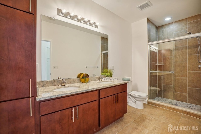 bathroom with vanity, a shower with shower door, and toilet