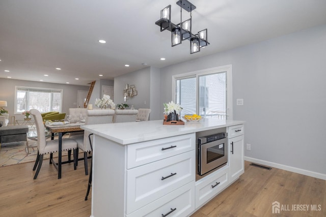 7 Winslow Ave, East Brunswick, NJ 08816 - kitchen featuring light wood-style flooring, open floor plan, white cabinets, recessed lighting, and decorative light fixtures