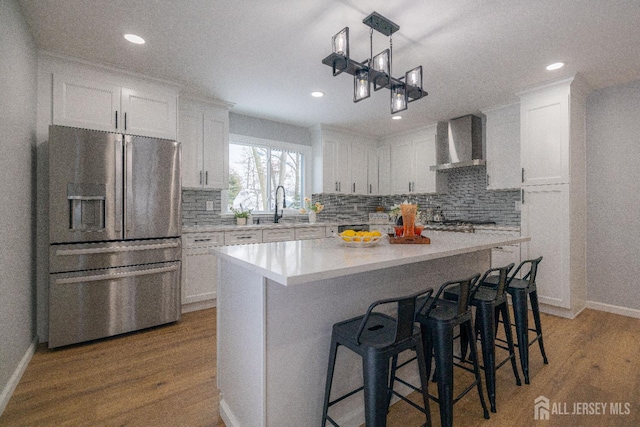 7 Winslow Ave, East Brunswick, NJ 08816 - kitchen with appliances with stainless steel finishes, wall chimney range hood, white cabinetry, wood finished floors, and recessed lighting