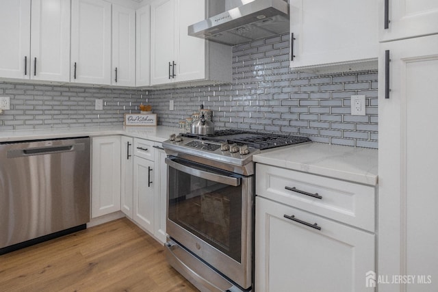 7 Winslow Ave, East Brunswick, NJ 08816 - kitchen featuring appliances with stainless steel finishes, range hood, white cabinets, and tasteful backsplash