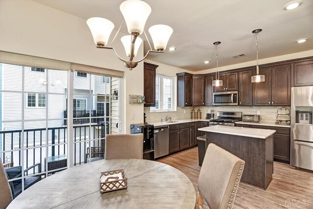2206 Stelmaszek Rd, Sayreville, NJ 08859 - kitchen with stainless steel appliances, dark brown cabinetry, light countertops, tasteful backsplash, and a kitchen island