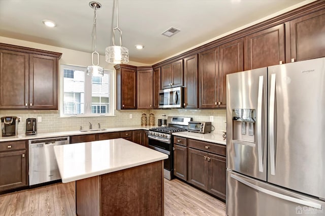 2206 Stelmaszek Rd, Sayreville, NJ 08859 - kitchen featuring appliances with stainless steel finishes, light wood-style flooring, tasteful backsplash, light countertops, and dark brown cabinetry