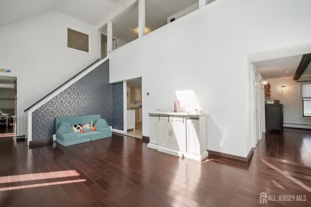 51 Greenbrook Rd, Middlesex, NJ 08846 - living room featuring wood finished floors, a baseboard heating unit, a towering ceiling, wallpapered walls, and stairs